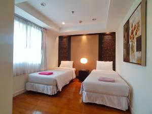 two beds in a hotel room with a window at Spacious apartment with Ocean view in Panwa in Phuket Town
