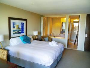 ein Hotelzimmer mit einem großen Bett und einem Bad in der Unterkunft Marine Boutique Apartments by Kingscliff Accommodation in Kingscliff