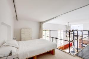 um quarto com uma cama e uma grande janela em Unit 010 Cherche Midi 19 em Paris