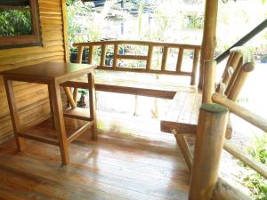 a wooden porch with a table and a bench at Suandarbporn Resort Mae Sot in Mae Sot