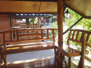 drewniana ławka siedząca wewnątrz budynku w obiekcie Suandarbporn Resort Mae Sot w mieście Mae Sot