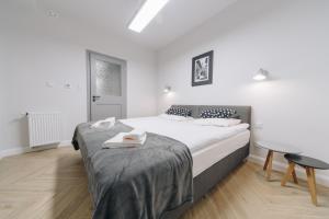 a white bedroom with a bed and a table at Platan Apartments-Unique -1 bedroom apartment in Krakow