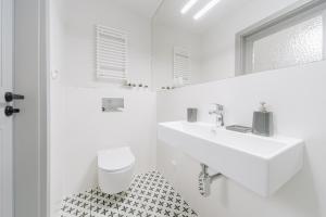 a white bathroom with a sink and a toilet at Platan Apartments-Unique -1 bedroom apartment in Krakow