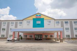 a large white building with a parking lot at SureStay Plus by Best Western Louisville Airport Expo in Louisville