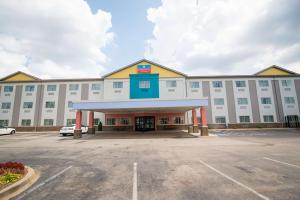 ein großes weißes Gebäude mit Parkplatz in der Unterkunft SureStay Plus by Best Western Louisville Airport Expo in Louisville