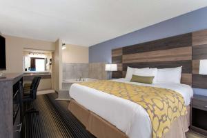 a hotel room with a large bed and a bathroom at Baymont by Wyndham Cheraw in Cheraw