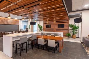 an office lobby with a bar with chairs and tables at Wingate by Wyndham Angola in Angola