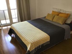 a bedroom with a bed with a yellow and white blanket at Appartement de 80m2 au cœur de Perpignan in Perpignan