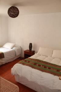 a bedroom with two beds and a table with a lamp at Hotel Velero Sur in Iquique
