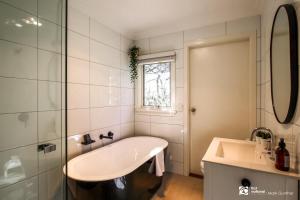 a white bathroom with a tub and a sink at Alsace - Healesville in Healesville