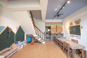 a room with a classroom with a table and a staircase at 安平寵物島 民宿 in Tainan