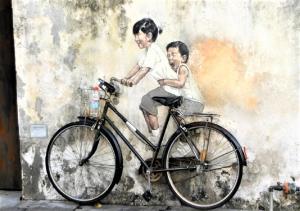een schilderij van een man en een kind op een fiets bij Rumahku Express, Georgetown, Penang in George Town