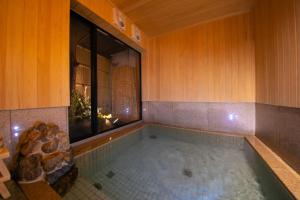 
a bath room with a tub and a window at Ohanabo in Kyoto
