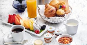 - une table avec des aliments pour le petit-déjeuner et une tasse de café dans l'établissement Shangri-La Kuala Lumpur, à Kuala Lumpur