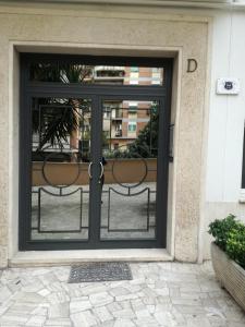 a glass door with two chairs inside of it at Testa Gioacchino B&B in Rome
