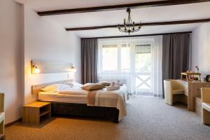 Un dormitorio con una cama grande y una ventana en Hotel Ariston, en Karpacz
