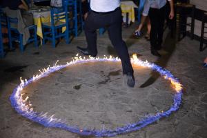 a man is jumping in front of a circle of fires at Aithrio Hotel in Niforeika