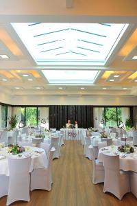 a banquet hall with white tables and white chairs at Hotel Bartoš in Frenštát pod Radhoštěm
