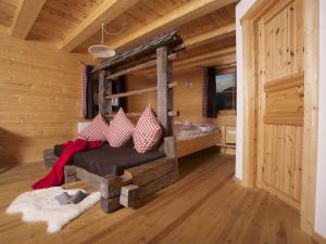 ein Schlafzimmer mit einem Bett in einem Blockhaus in der Unterkunft Bio Natur Refugium Blaslahof **** in Gsieser Tal