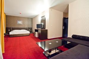 une chambre d'hôtel avec un lit et un tapis rouge dans l'établissement семеен ХОТЕЛ РОМАНТИКА, à Haskovo