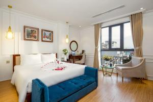 a bedroom with a large bed and a blue couch at Menora Grand Da Nang in Da Nang