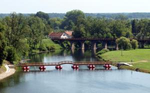 a bridge over a river with a train crossing it at Apartman Malina in Karlovac