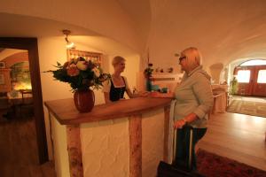 タムスヴェークにあるHotel Pension Kandolfの二人の女性が部屋のカウンターに立っている