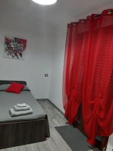 - une chambre avec un lit et un rideau rouge dans l'établissement Domos Loru, à Sestu