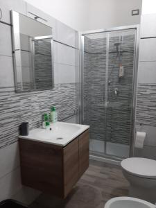 La salle de bains est pourvue d'une douche, d'un lavabo et de toilettes. dans l'établissement Domos Loru, à Sestu