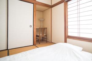 Postel nebo postele na pokoji v ubytování RIVERSIDE INN KAMAKURA