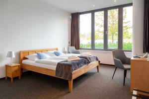 sypialnia z łóżkiem i dużym oknem w obiekcie Hotel Vivendi w mieście Paderborn