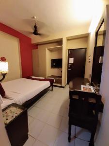 Pokój hotelowy z 2 łóżkami, biurkiem i łóżkiem o wymiarach 6 x 6 w obiekcie Ravi Krishna Inn w mieście Puducherry