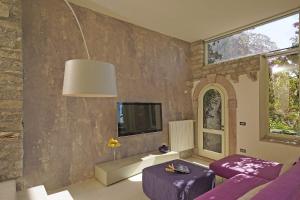 een woonkamer met paarse meubels en een muur bij Villa Rachele: stunning luxury villa in centre Gargnano with private pool and breathtaking views in Gargnano
