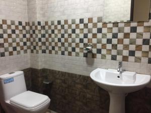 a bathroom with a toilet and a sink at Brindavan Residency in Ettumānūr