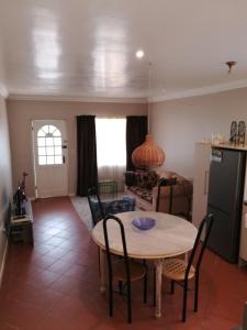 a kitchen and living room with a table and chairs at Lucias Cottage in Cape Town