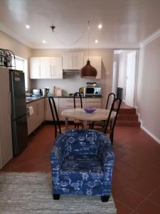 a kitchen with a table and chairs and a kitchen with a refrigerator at Lucias Cottage in Cape Town