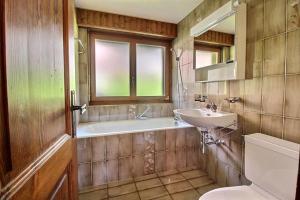 a bathroom with a sink and a tub and a toilet at Skirama 018 in Verbier