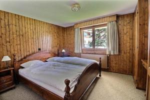 a bedroom with a large bed in a room with wooden walls at Skirama 018 in Verbier