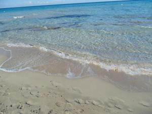 a sandy beach with the ocean and the water at Residence Massilor in Gallipoli