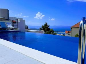 a large blue swimming pool on the side of a house at Villa Nina 1 Makarska in Makarska