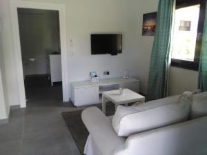 sala de estar con sofá blanco y TV en Eco Lodge Self-Catering en Mahe