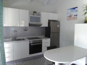 a kitchen with a sink and a refrigerator and a table at Eco Lodge Self-Catering 1-2 in Mahe