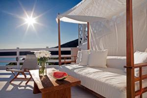 a bed and a table with a bowl of watermelon on a deck at Hotel Perrakis in Kipri