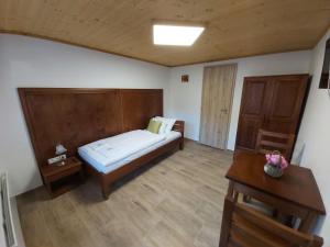 Mamutfenyő Panzió في تاتا: غرفة نوم بسرير و اللوح الخشبي