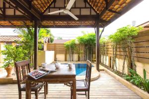 a patio with a table and chairs and a pool at BTC Hua Hin Home managed by BTC Boutique Resort in Hua Hin