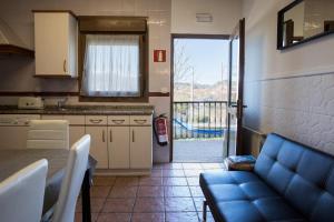 a kitchen with a table and a blue couch in a room at Makala apartamentuak in Zarautz