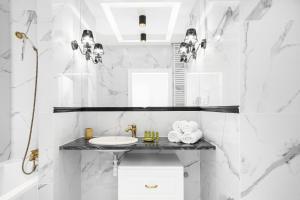 een witte badkamer met een wastafel en een spiegel bij Apartments Aura Sky by Renters in Warschau