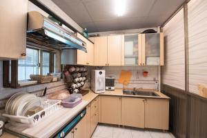 a small kitchen with wooden cabinets and a sink at 安平寵物島 民宿 in Tainan