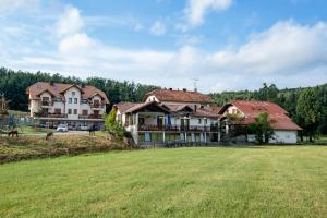 uma casa grande com um campo de relva em frente em EkoTurizem Hudičevec em Postojna