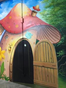 a painting of a mushroom house with a umbrella at 23 Here B&B in Hualien City